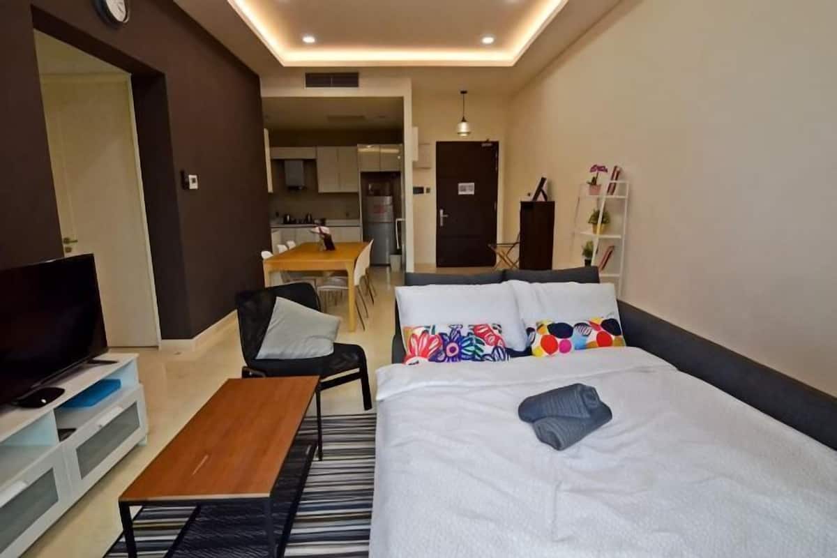 Une chambre d’hôtel équipée d’un lit, d’une télévision, d’un bureau et d’une kitchenette.