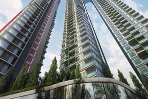 Un edifici residencial alt amb nombroses balcons i una façana de vidre corbat.