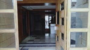 A hallway with a checkered floor, wooden walls, and glass panels. - Hassan II Mosque Casa International Fair (Casablanca)