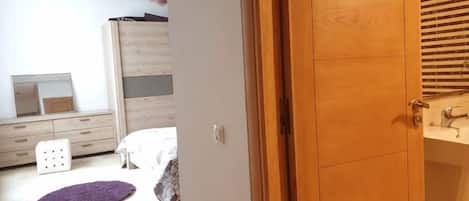 Ein Schlafzimmer mit einem Bett, einer Kommode und einem Fenster.