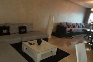 Una sala de estar con un sofá seccional, una mesa de centro y una lámpara.