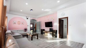 Un salon moderne avec un canapé gris, une table basse et un téléviseur fixé au mur.
