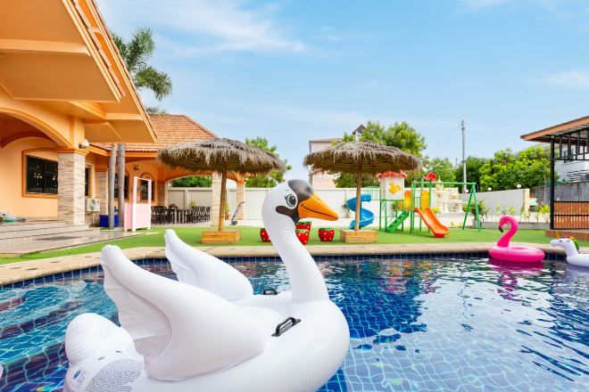 A swimming pool with a swan float and a flamingo float.
