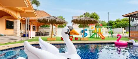 A swimming pool with a swan float and a flamingo float.