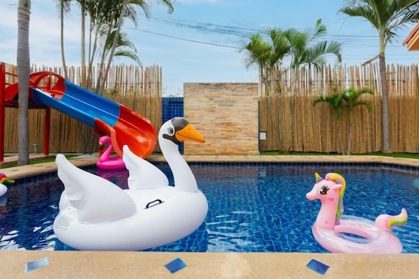 Una piscina con flotadores de cisne e unicornio inflables.