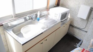 A compact kitchen with a sink, a microwave, and a small countertop.