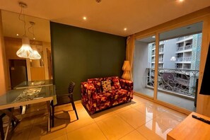 Una sala moderna con una mesa de vidrio, un sofá y vistas a un balcón con barandilla.