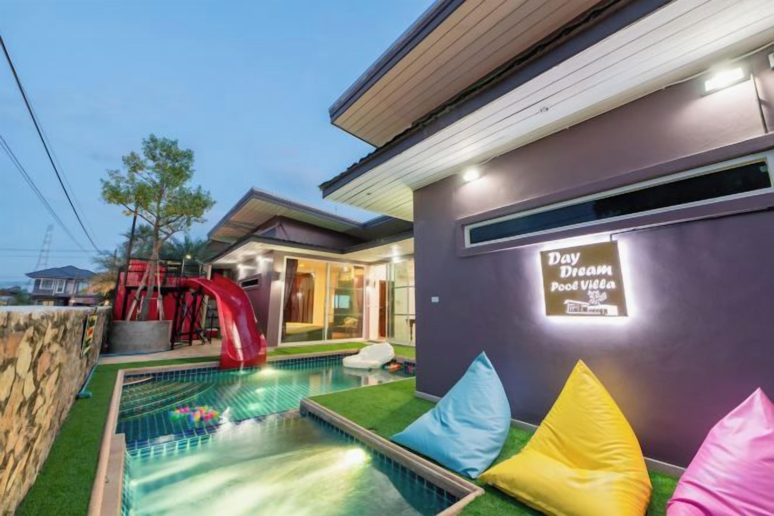 Une maison moderne dotée d’une piscine, d’un toboggan et d’un panneau indiquant « Villa avec piscine, idéale pour se détendre ».
