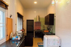 A narrow kitchen with a refrigerator, cabinets, and a small countertop. - DayDream Pool Villa (Bang Lamung)