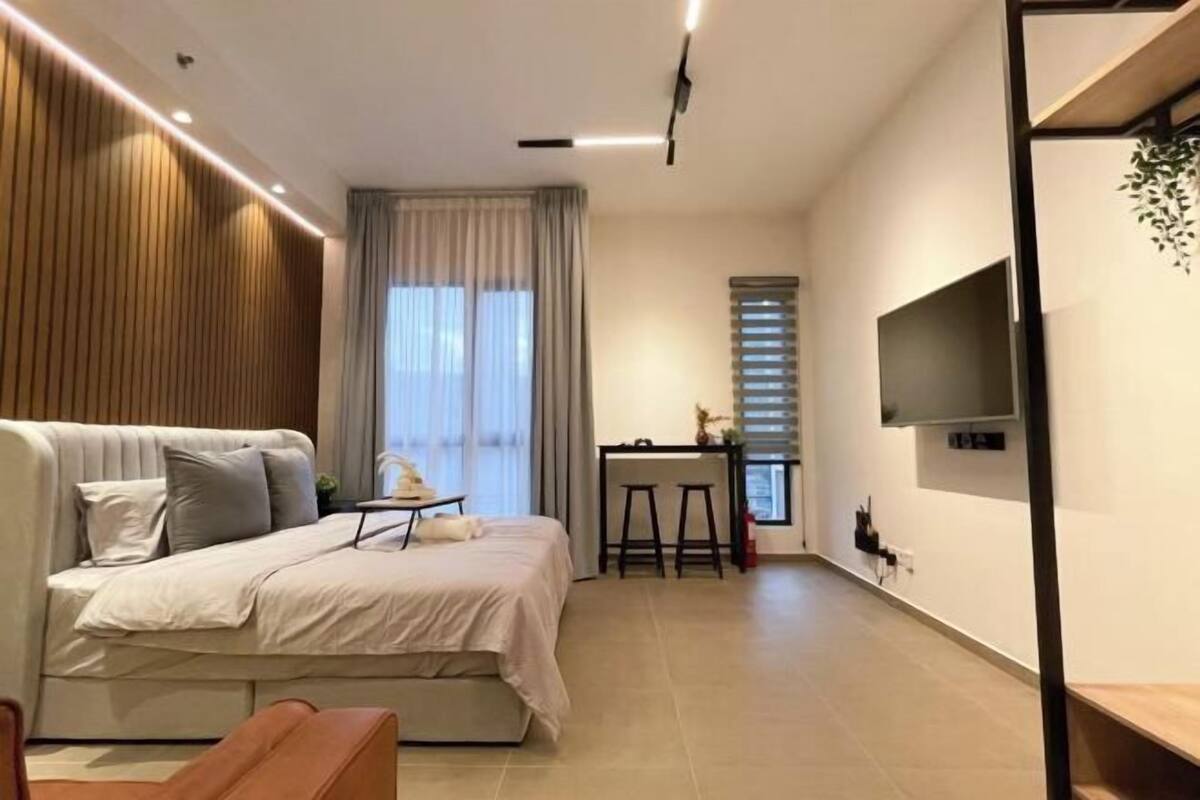 Un dormitorio moderno con cama, escritorio y televisor.