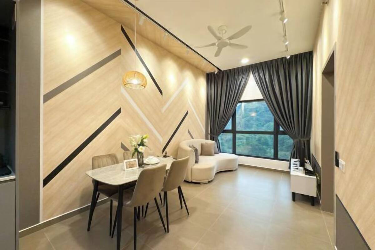 Una sala de estar moderna con comedor, un sofá, un ventilador de techo y vistas amplias a través de grandes ventanales.