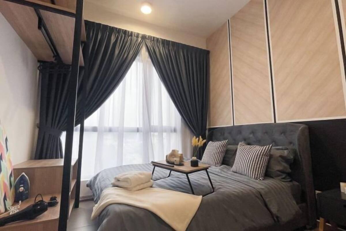 Un dormitorio moderno con una cama grande, una mesita de noche y una ventana con cortinas.