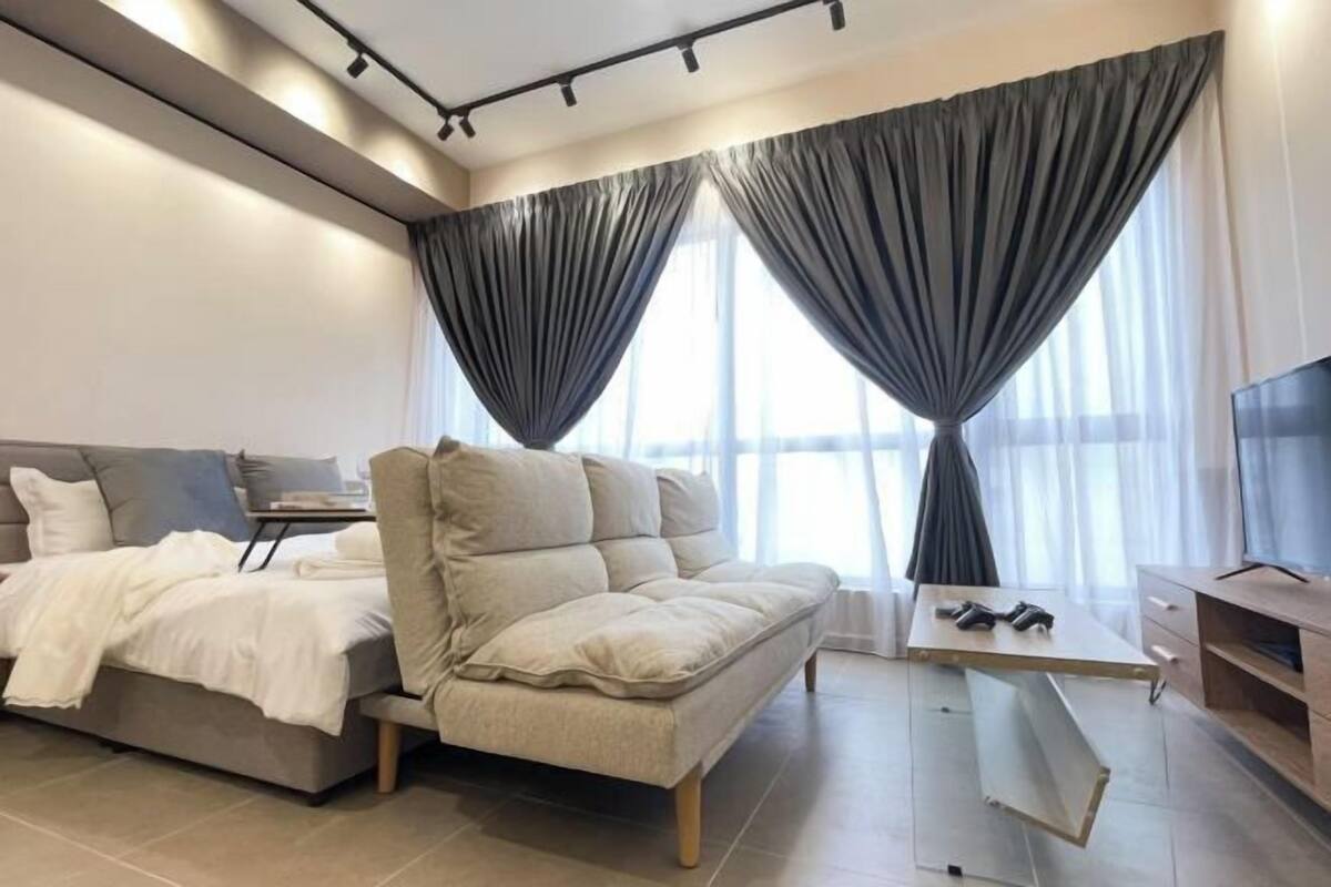 Una sala de estar moderna con un sofá, una mesa de centro, un televisor y un escritorio con una silla.