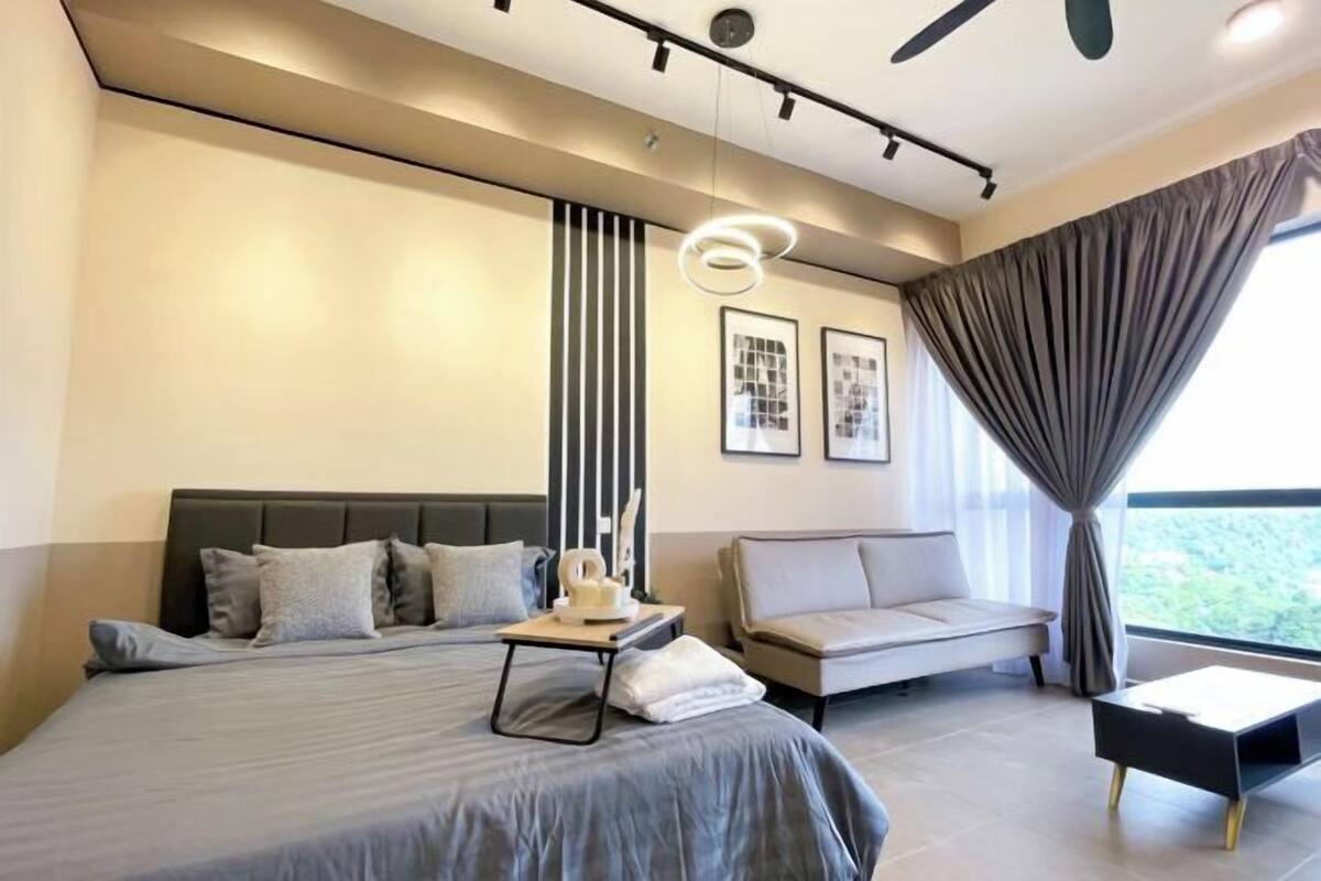 Un dormitorio moderno con una cama grande, un sofá, una mesita y un ventilador de techo.