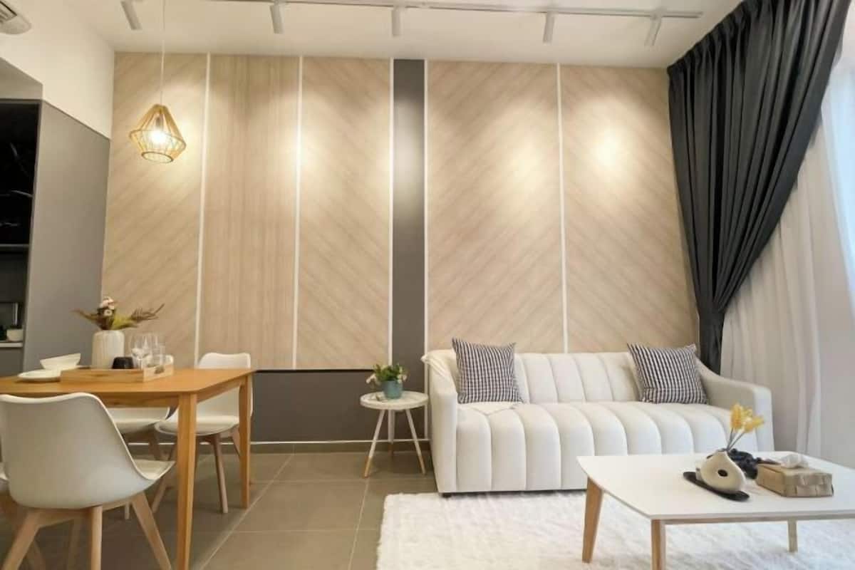A modern living room with a sofa, coffee table, and dining area.