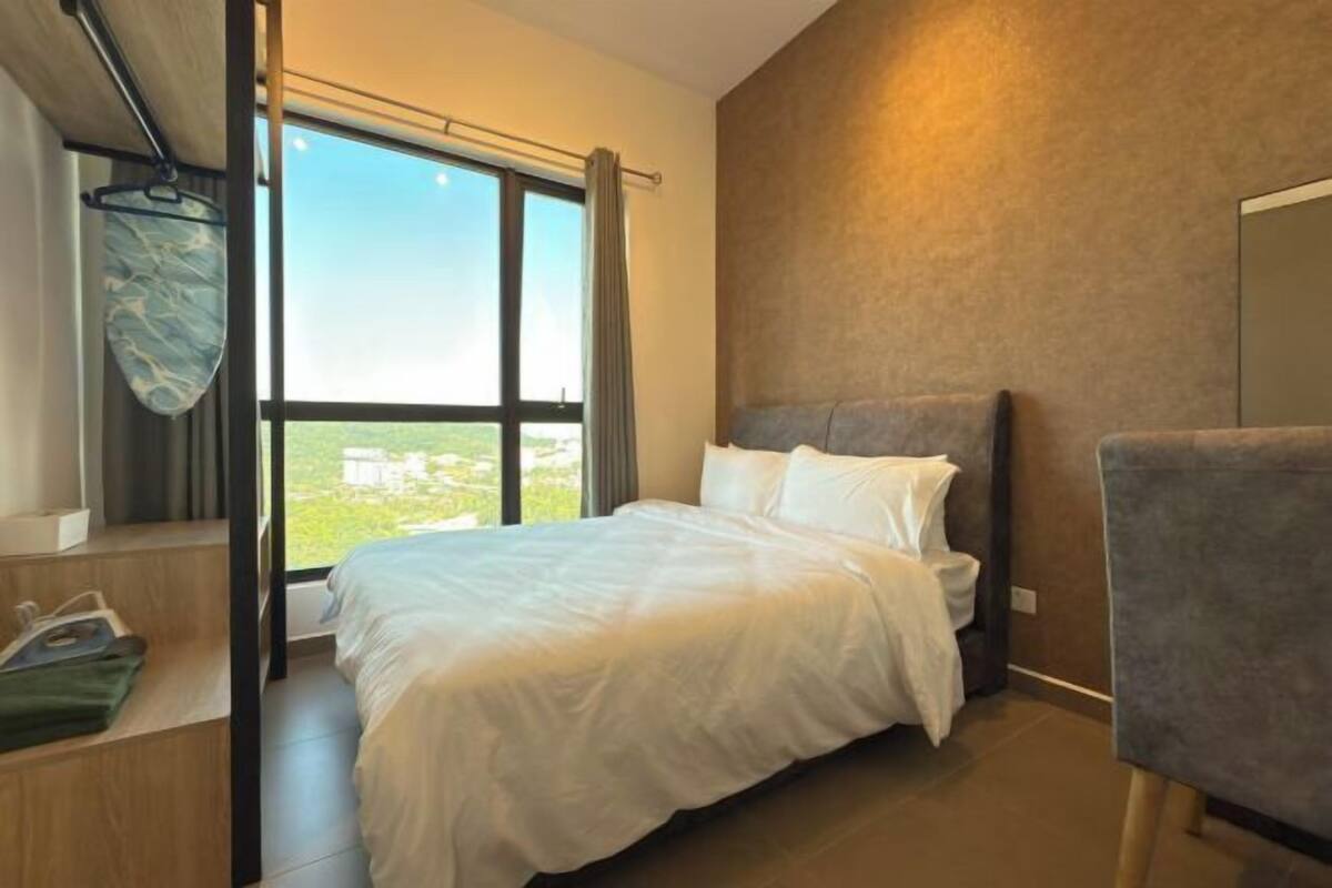 Una habitación de hotel moderna con una cama grande, vistas por una ventana y una silla.
