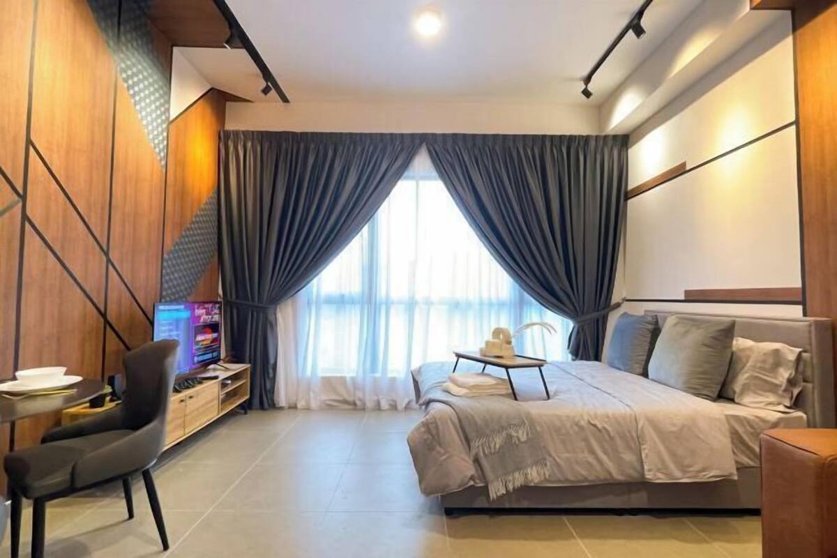 Una habitación de hotel moderna con cama, escritorio, silla y televisor.