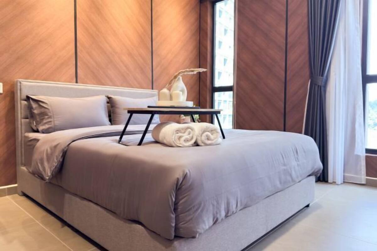 Un dormitorio moderno con cama, una mesita de noche con lámpara y una ventana con cortinas.