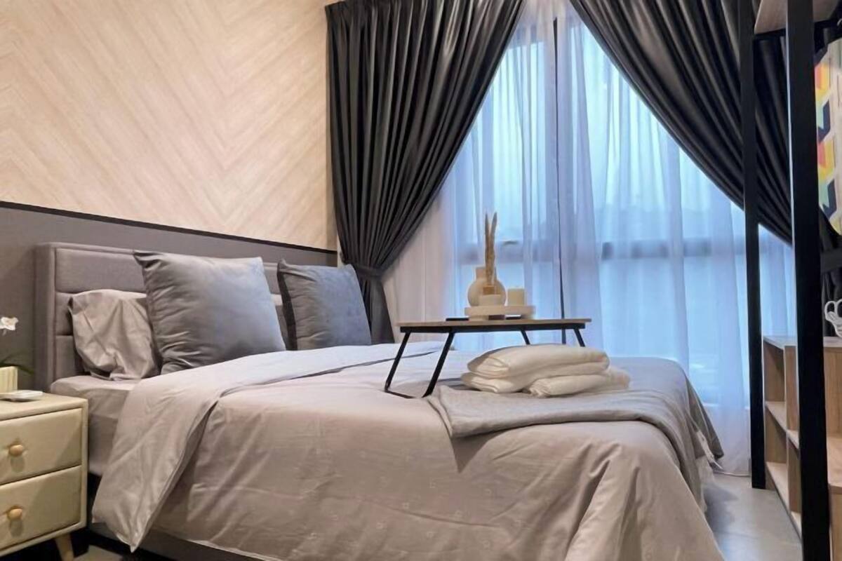 Un dormitorio moderno con cama, mesita de noche y una pequeña mesa con lámpara.