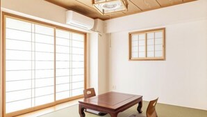 Una tradizionale stanza giapponese con pavimento in tatami, un tavolo in legno e porte scorrevoli.