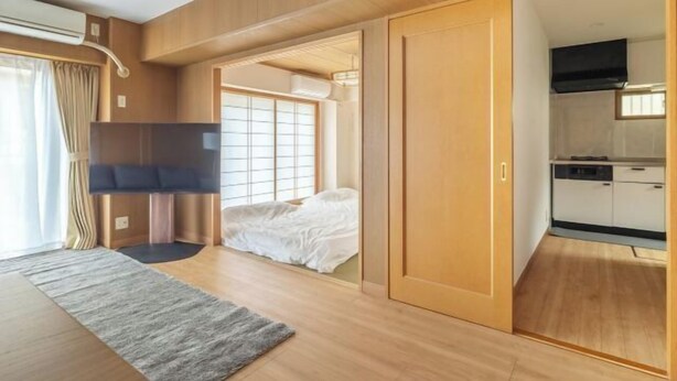 Una stanza funzionale con un letto, una TV e angolo cottura.