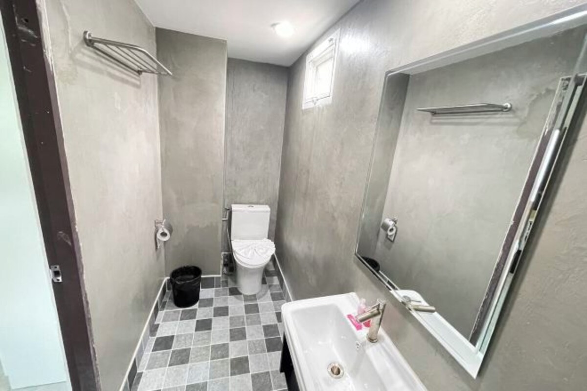 A small bathroom with a toilet, sink, and mirror.