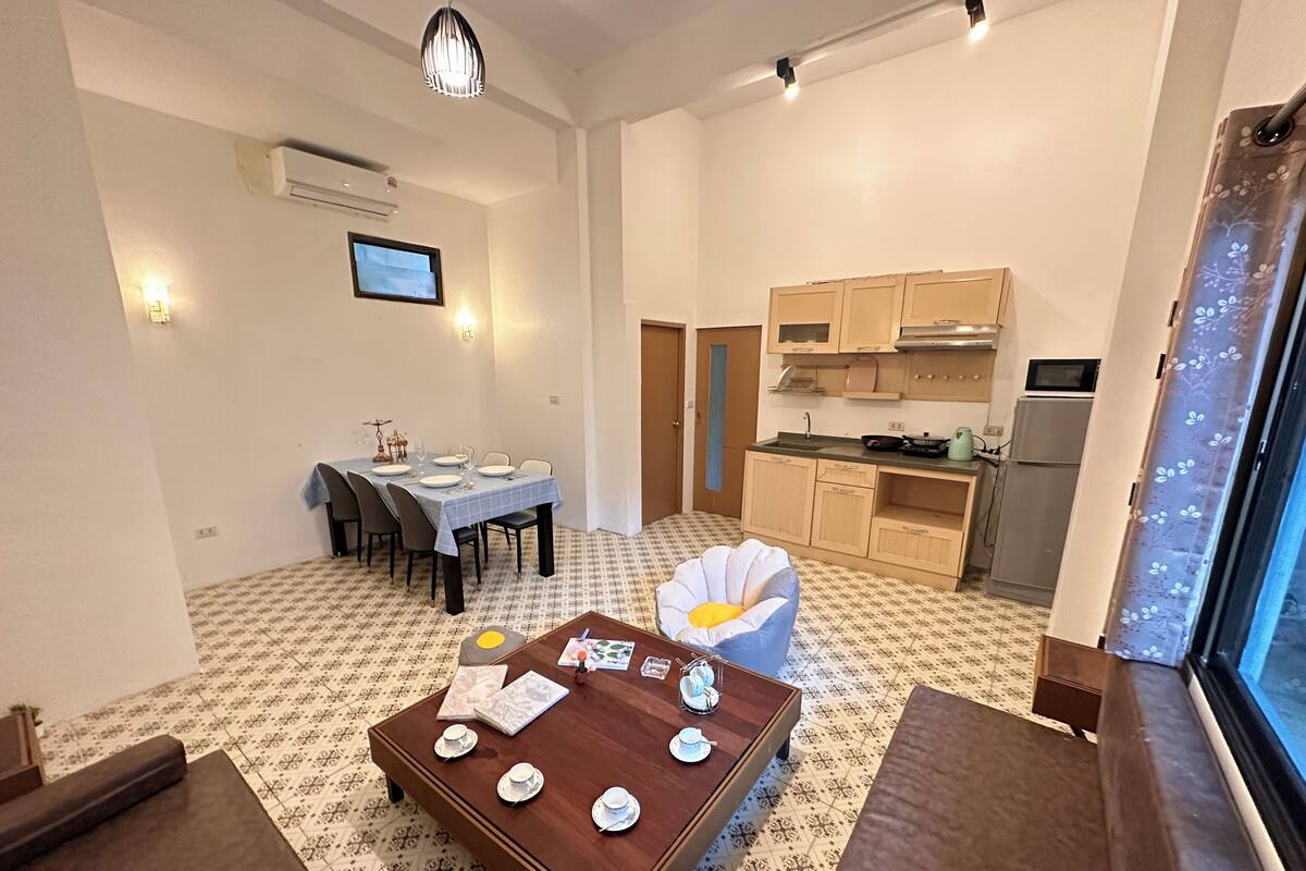 A compact living space with a dining area, a kitchen, and a seating area with a coffee table.
