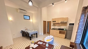 A compact living space with a dining area, a kitchen, and a seating area with a coffee table.