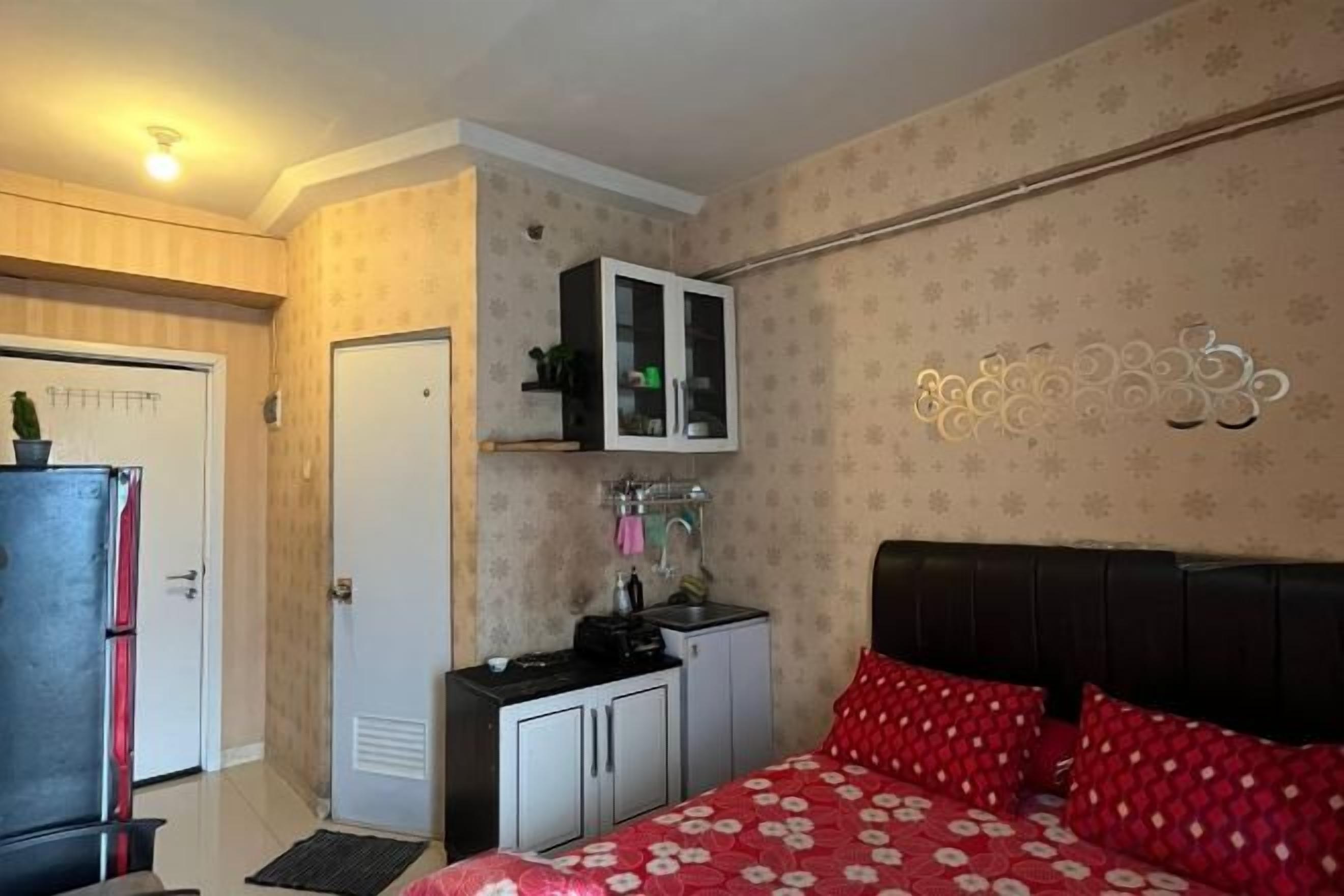 A bedroom with a bed, a wardrobe, a small desk, and a cabinet.