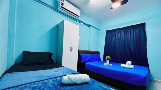 A room with two beds, a wardrobe, an air conditioning unit, and a ceiling fan. - Relax Familystay usm 3BR 2-6 pax (Gelugor)
