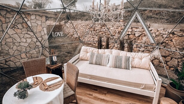 A geodesic dome structure with a hanging chandelier, a cushioned seating area, a round table with a placemat, and a small potted plant. - Apartment 'Suite Romántica' with Mountain View, Wi-Fi and Air Conditioning (Canyelles)