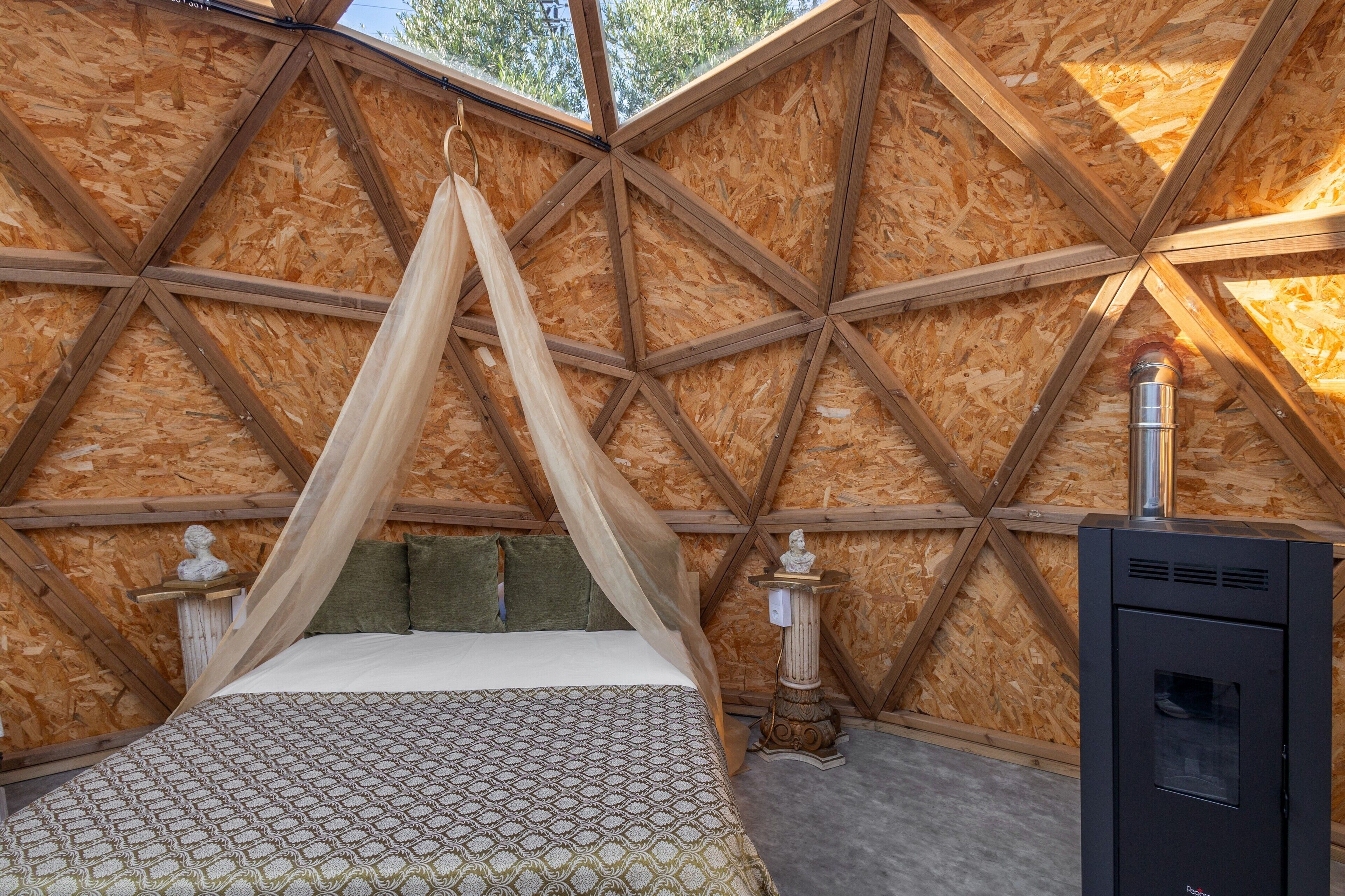 A room with a bed, a canopy, a statue, and a heater.