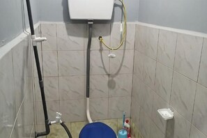 Ein kleines Badezimmer mit Toilette, Dusche und Waschbecken.