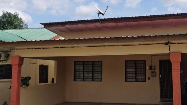 A building with a flat roof, a satellite dish, and a gated entrance. - Homestay Che Wan Satu (Kuala Kuantan)