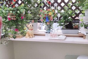 A room with a white counter, a small dog figurine, and various potted plants. - Tokyo Yoshihisa Garden Hotel (Tokyo)