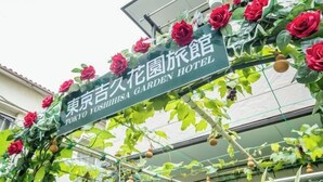 Een bordje voor het Tokyo Yushiba Garden Hotel, met een groene treillis versierd met rode rozen.