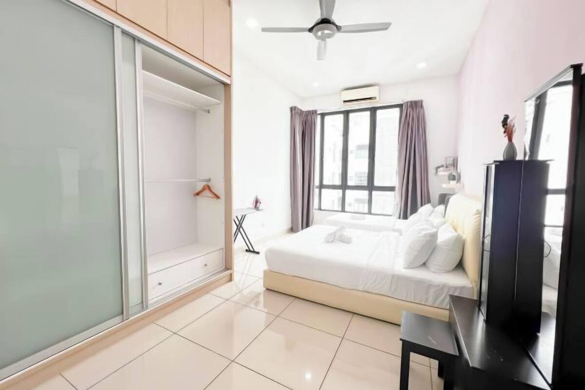 A modern bedroom with a bed, a TV, and a wardrobe.
