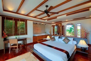 A bedroom with a large bed, a desk, and a ceiling fan. - Patong Seaview Luxury Villa Penda (Phuket)