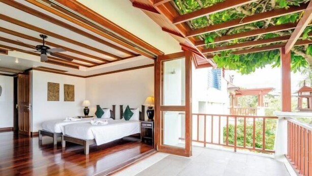 A bedroom with a wooden ceiling, a balcony with a view, and a bed with white linens. - Patong Seaview Luxury Villa Penda (Phuket)