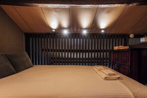Ein Schlafzimmer mit einem Bett, Holzlamellen und einem Nachttisch.