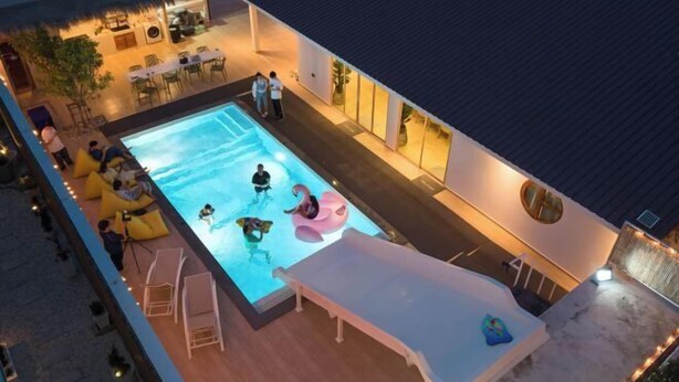 A rooftop pool area with a swimming pool, lounge chairs, and a covered seating area. - De Beach pool villa. New Villa 3 min walk from the beach 5 rooms (Pattaya)