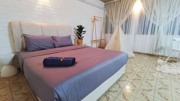 A bedroom with a bed, a hanging plant, a wooden swing, and a tent.