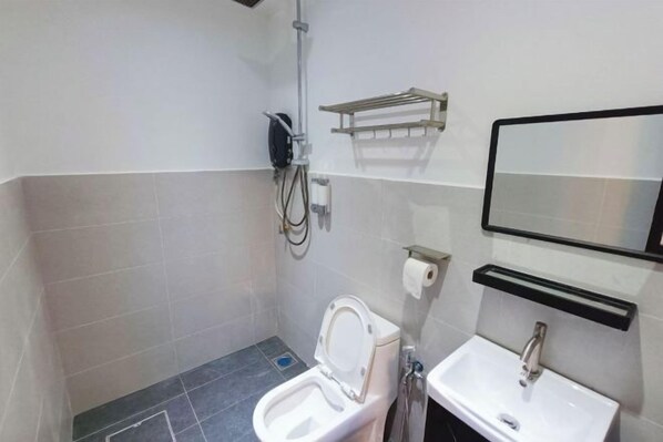 A small bathroom with a toilet, sink, and mirror. - TF Klebang Private Pool Villa (Melaka Tengah)