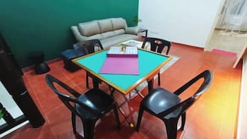 Un comedor con una mesa, cuatro sillas, un sofá y una alfombra pequeña.