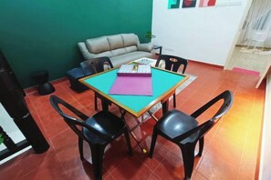Un comedor con una mesa, cuatro sillas, un sofá y una alfombra pequeña.