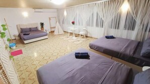 Ein modernes Zimmer mit einem Bett, zwei Sofas, einem kleinen Tisch und einer zeltartigen Konstruktion.