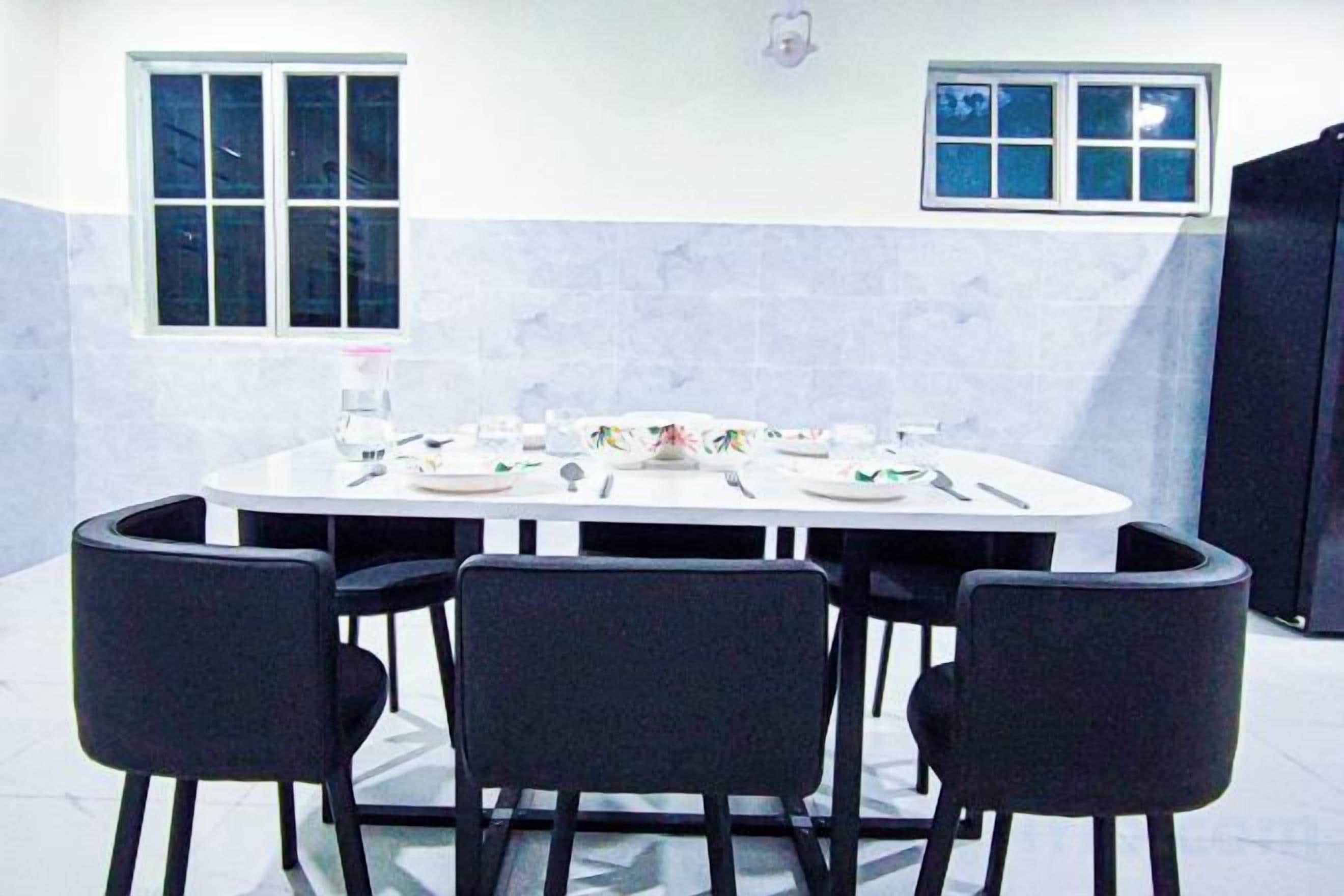 Un salón de conferencias con una mesa redonda, cuatro sillas y un ventanal.