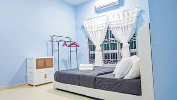Un dormitorio con cama, cómoda, cortinas en la ventana y aire acondicionado.