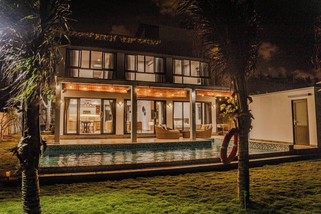 A two-story building with a swimming pool, outdoor seating, and a lifebuoy.