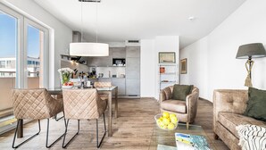 Een modern appartement met een eetgedeelte, keuken en woonkamer.